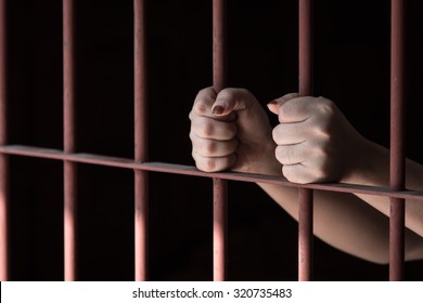 Hands Of Muslim Woman Holding Bars In Jail