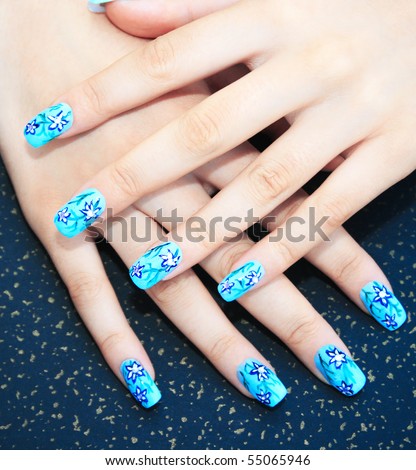 Hands with nail art on spotted background.