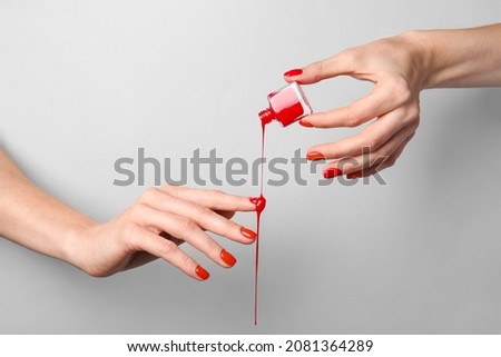 Hands with nail polish on grey background