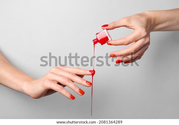 Hands with nail\
polish on grey background