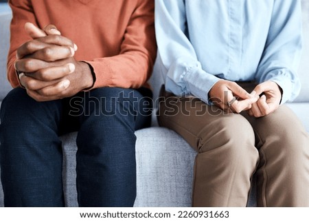 Hands, nervous and couple in waiting room for results, cancer and bad news, diagnosis and stress. Hand, anxiety and man with woman on sofa for depression, marriage counseling or divorce discussion