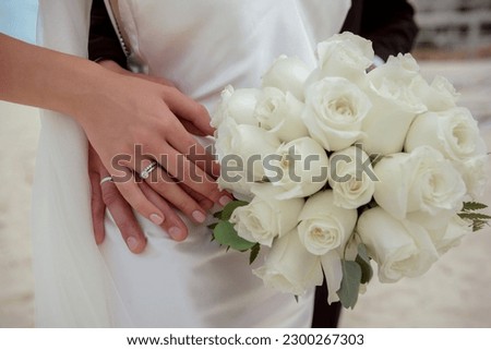 Hands newlyweds with a bouquet. A newly weding couple place their hands on a wedding bouquet Photo stock © 