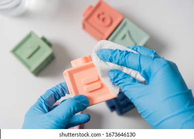 Hands In Nitrile Gloves Are Cleaning And Disinfecting Toys