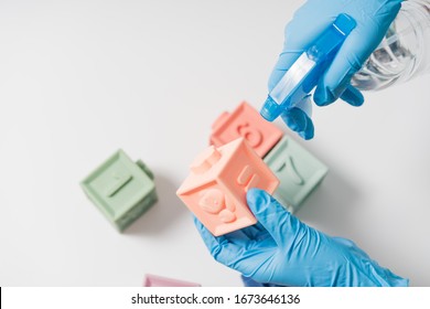 Hands In Nitrile Gloves Are Cleaning And Disinfecting Toys