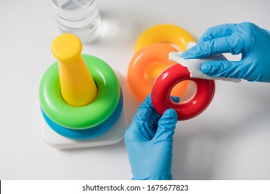 Hands In Nitrile Gloves Are Cleaning And Disinfecting Toys