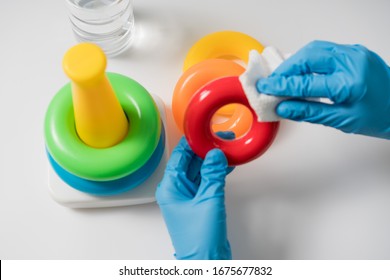 Hands In Nitrile Gloves Are Cleaning And Disinfecting Toys