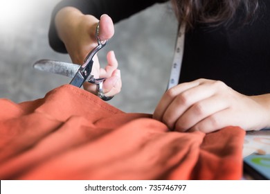 Hands notch tailor tailor's scissors cloth cutting a piece of fabric (fashion designer concept) - Powered by Shutterstock