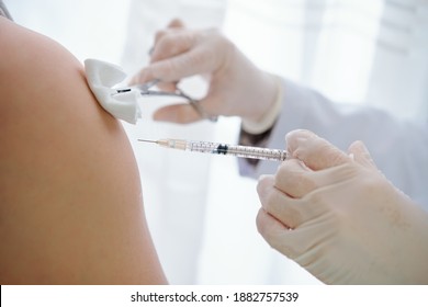 Hands Of Nurse Wiping Injection Site On Arm Of Patient With Cotton Ball Before Vaccinate Him Against Coronavirus