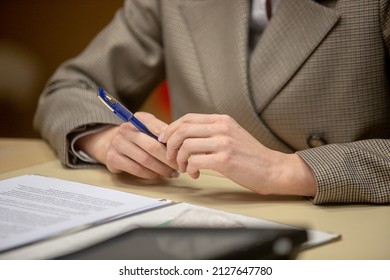 Hands of an official, speaker or boss during a press conference - meeting with the press. Speaker at the talks. Blank plate to indicate the name and position. Close-up. No face