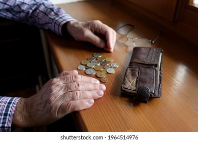Hands of an old man counting coins. 