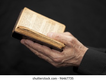 Hands Of An Old Man Holding A Book
