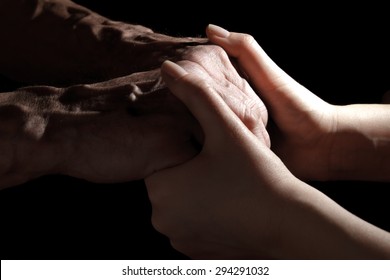 Hands Of The Old Man And A Young Woman. In Low Key. Toning