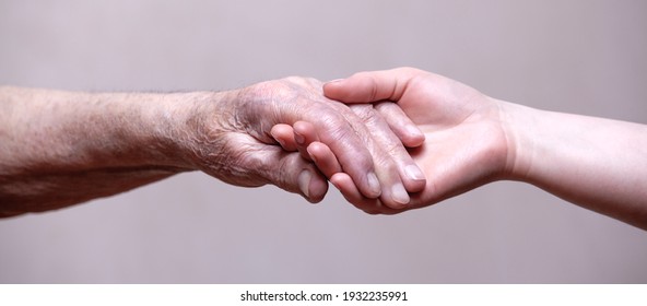 Hands Of The Old Man And A Young Woman.Helping Hands.