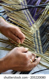 Hands of an old Maori woman from New Zealand weaving a traditional Polynesian woven artwork