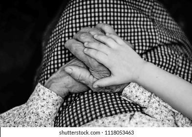 Hands Of Old Woman And Child.  Helping Hands, Care For The Elderly Concept.  Black And White