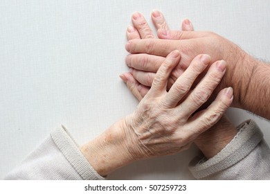Hands of an old woman holding the hand of a man (son,grandson,doctor,helper). Lonliness, help and patronage concept