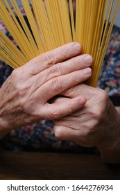 Hands Of Old Woman Holding Pasta. Selective Focus