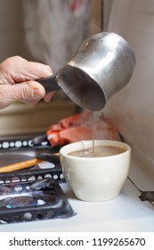 Hands Of Old Woman Serving Coffee In A Cup