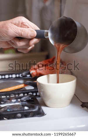 Hands of old woman serving coffee on a cup
