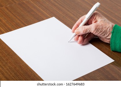 Hands of an old woman with a sheet for writing text