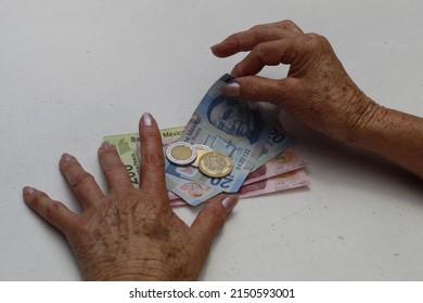 Hands Of An Older Woman Holding Mexican Money