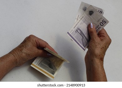 Hands Of An Older Woman Holding And Paying With Danish Money