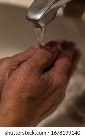 Hands Of An Older Woman With Painted Nails On Water Running From A Tap. She Is Washing Her Hands.