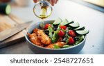 Hands, olive oil and salad in kitchen, home and meal prep with seasoning, meat or flavor with vegetables. Person, chef and bowl with food for nutrition, wellness or gut health with diet at apartment