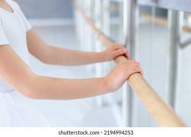 Hands On Barre In Ballet School. Little Ballerina Studying In Classical Dance Class Room. Child Girl Training In Studio. Kid Has Dancing Workout. Practicing For Children, Small Dancer. Close Up