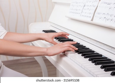 Hands on the white Keys of the Piano Playing a Melody. Women's Hands on the Keyboard of the Piano, Playing the Notes Melody. Hands of young Girl, Music on the  Piano                              