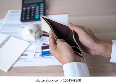 Hands open the empty purse after calculating the cost from the credit card and bill. debt concept - Shutterstock ID 1501549268