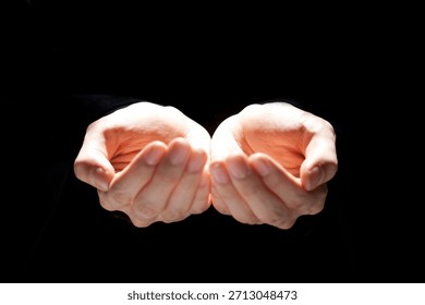Hands open in empty space expressing a moment of pause and reflection in a dark setting