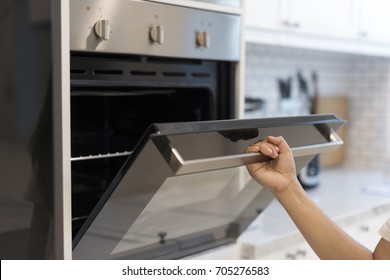 Hands Open The Oven In The Kitchen