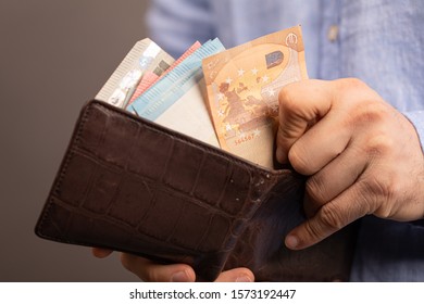 Hands opening a leather wallet with Euro banknotes inside - Shutterstock ID 1573192447