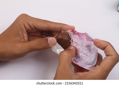 hands opening a pack of chocolate candy