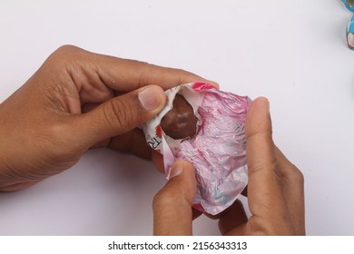 hands opening a pack of chocolate candy
