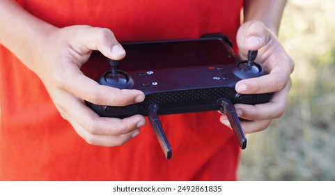 hands operating a drone in the field - Powered by Shutterstock