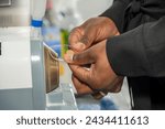 hands of an optician working a sight glass to make a pair of glasses with a beveler