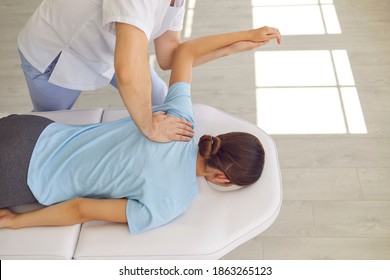 Hands of osteopath masseur doctor fixing lying woman patients back and shoulder joint during visit in manual therapy clinic, top view. Professional chiropractor during work with patient concept - Powered by Shutterstock
