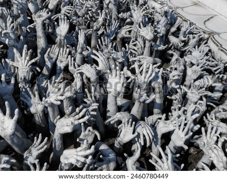 Hands outreaching from hell at the White Temple (Wat Rong Khun) in Chiang Rai, Thailand. These symbolize unrestrained desire, that the way to happiness is by foregoing temptation, greed and desire.