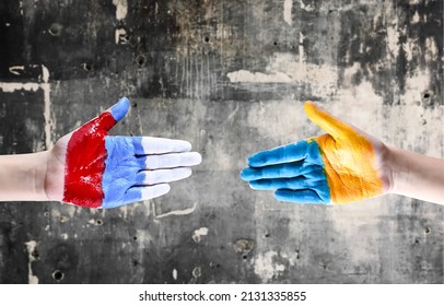 Hands Painted In The Colors Of The Flags Of Ukraine And Russia Reach Out To Each Other. The Concept Of Reconciliation Of Peoples. No War.
