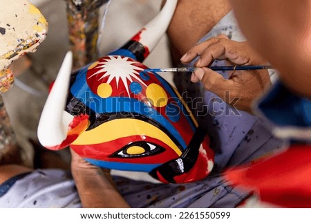 hands painting bull mask carved in wood and painted with commemorative colors of the carnival of barranquilla colombia