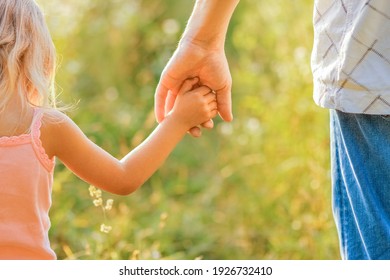 hands of parent and child outdoors in the park