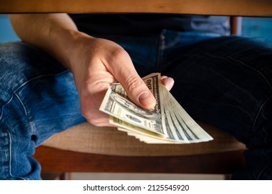 Hands Passing Money Under Table Corruption Bribery, Businessman Sealing The Deal With A Handshake And Receiving A Bribe Money.