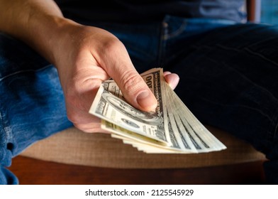 Hands Passing Money Under Table Corruption Bribery, Businessman Sealing The Deal With A Handshake And Receiving A Bribe Money.