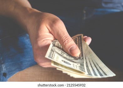 Hands Passing Money Under Table Corruption Bribery, Businessman Sealing The Deal With A Handshake And Receiving A Bribe Money.