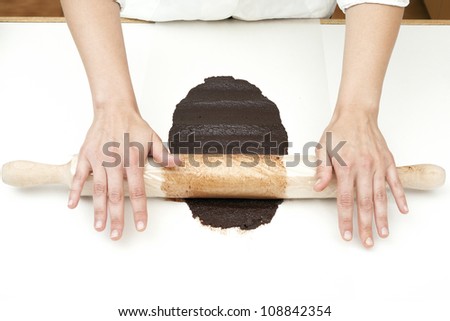 hands of a pastry roll kneading with a chocolate mass