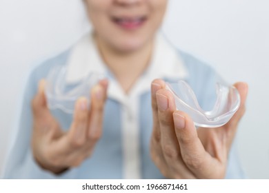 Hands Of Patient With Sleep Bruxism Disease,asian Female Holding An Occlusal Splint To Help Care Support Her Tooth While Sleeping At Night,protect Teeth From Grinding In Bedtime,dental Health Concept