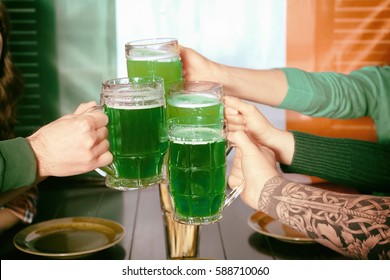 Hands Of People With Beer Celebrating Saint Patrick Day In Pub