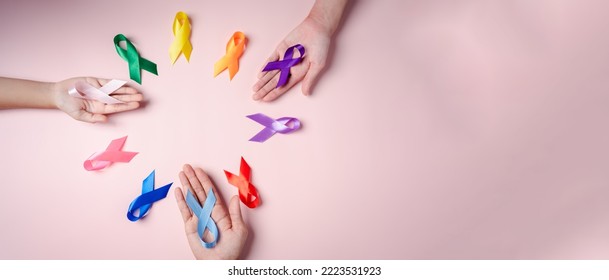 Hands of people holding colorful ribbons on pink background, cancer awareness, World cancer day, National cancer survivor day, world autism, supported living and illness, Prostate awareness concept. - Powered by Shutterstock